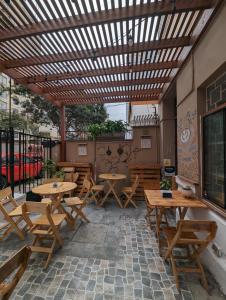 un patio con mesas de madera y bancos de madera en Hospedaje Boutique Albergue Verde, en Lima