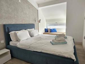 um quarto com uma cama grande e almofadas brancas em Golden Sunset Apartments em Ohrid