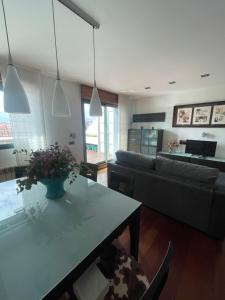 a living room with a couch and a table at EL ÁTICO DE LA PLAYA Parking gratis in Gijón +25 photos