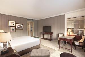 um quarto com uma cama, uma secretária e uma televisão em The Ritz-Carlton Osaka em Osaka