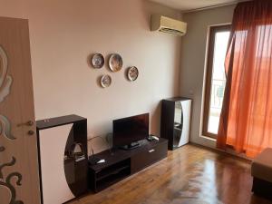 sala de estar con TV y espejo en la pared en apartment DIAMOND SARAFOVO, en Burgas