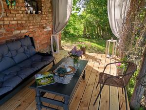 eine Terrasse mit einem Tisch und einem Sofa auf einer Terrasse in der Unterkunft Przystanek Rospuda in Sucha Wieś