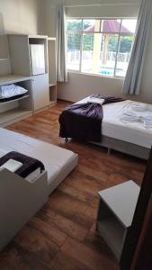 1 dormitorio con 2 camas y ventana en Hotel Panorâmico, en Penha