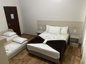 1 dormitorio con 2 camas y almohadas blancas en Hotel Panorâmico, en Penha