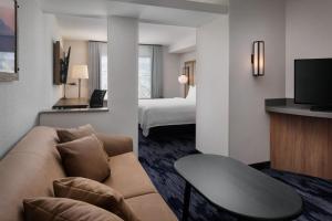 a hotel room with a couch and a bed at Fairfield Inn & Suites by Marriott Kelowna in Kelowna