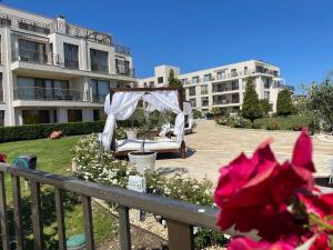 un patio con un letto e un baldacchino di fronte a un edificio di Diamond Beach Garden Apartment a Burgas