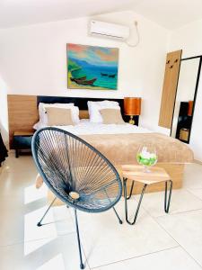 a bedroom with a bed and a chair and a table at Hotel Lagadin in Ohrid