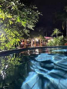a swimming pool at night with trees and lights at Casa de Campo in Milagro
