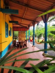 a patio with a hammock and tables and chairs at Casa de Campo in Milagro