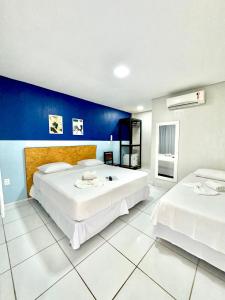 two beds in a room with a blue wall at Pousada Vila Mansa Jeri in Jericoacoara