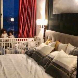 a bed with a crib and a baby in a room at Appartement La Suite Royale Centre Luxembourg 2 chambres in Luxembourg