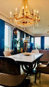 uma sala de jantar com uma mesa e um lustre em Appartement La Suite Royale Centre Luxembourg em Luxemburgo
