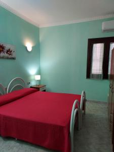 キアにあるLa Rosa dei Venti B&Bのベッドルーム1室(赤いベッド1台、椅子2脚付)