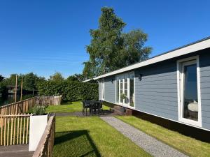 a tiny house with a patio and a table at NEW - Waterhouse Linada on a lake near Amsterdam in Vinkeveen