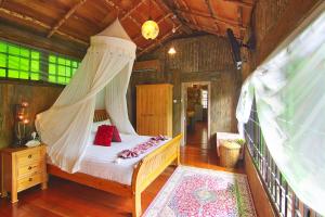 a bedroom with a bed with a mosquito net at Fig Tree Hills Resort (花果山度假村) in Bayan Lepas +76 photos