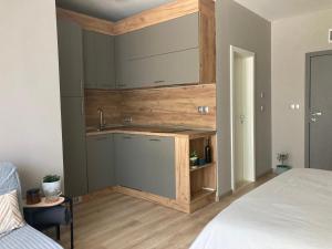 uma cozinha com um lavatório num quarto com uma cama em Cozy studio by the seaside em Byala