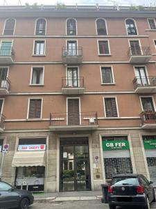um grande edifício com carros estacionados em frente em Apartment via Ferrucci 22 em Milão
