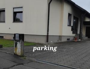 un edificio blanco con la palabra aparcamiento escrito en él en Ferienwohnung Teranga, en Jettingen-Scheppach