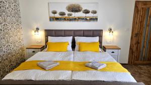 Un dormitorio con una cama grande con almohadas amarillas. en Apartmány Podzámčí, en Lednice
