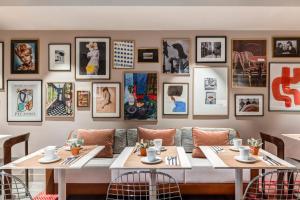 ein Restaurant mit zwei Tischen und Bildern an der Wand in der Unterkunft Republik Hotel in Lyon