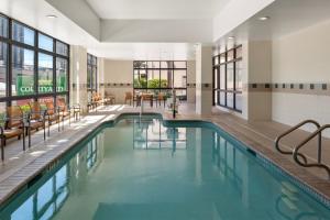 uma piscina no átrio do hotel com cadeiras e mesas em Courtyard by Marriott Houston Galleria em Houston