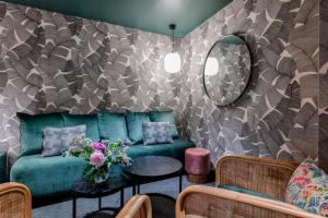 ein Wohnzimmer mit einem grünen Sofa und einem Spiegel in der Unterkunft Republik Hotel in Lyon