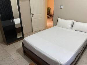 ein Schlafzimmer mit einem großen weißen Bett in einem Zimmer in der Unterkunft Harmony house apartments in Ker Bakary