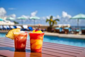 dos bebidas sentadas en una mesa junto a una piscina en Marriott's BeachPlace Towers, en Fort Lauderdale