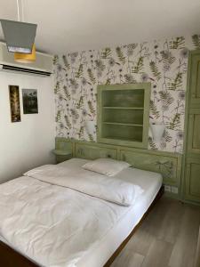 a bedroom with a white bed with a floral wallpaper at Hotel Antico in Intragna