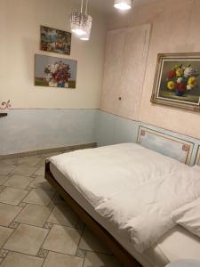 a bed in a room with two pictures on the wall at Hotel Antico in Intragna