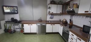 a kitchen with white cabinets and a stainless steel refrigerator at As Mariñas 92 in Boiro