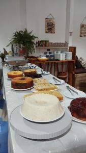 a table with different types of cakes and pies at Pousada Ponta da Baleia in Barra Grande