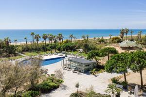 een luchtzicht op een resort met een zwembad en het strand bij AC Hotel Gava Mar in Gavà