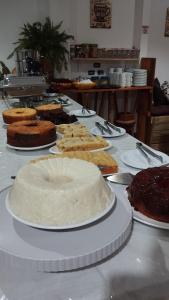 a table with many different cakes and cakes on at Pousada Ponta da Baleia in Barra Grande