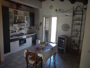 ノートにあるCasa Vacanze - Attico Dorisのテーブル付きのキッチン、窓付きのキッチンが備わります。