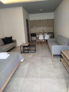 a living room with two couches and a kitchen at Billy´s Seaside Apartment in Iraklitsa