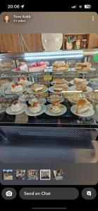 une vitrine avec des gâteaux et des gâteaux sur les assiettes dans l'établissement Morud, à Meistervik