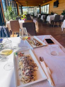a table with two plates of food and glasses of wine at Gent's Inn Luxury in Durrës