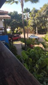 a view of a parking lot with palm trees and cars at Pousada Ponta da Baleia in Barra Grande