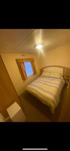 - une petite chambre avec un lit et une fenêtre dans l'établissement Static Caravan Marine Holiday Park, à Rhyl