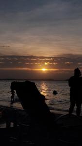 a person standing on the beach at sunset at Pousada Ponta da Baleia in Barra Grande