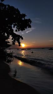 a sunset on the beach with the sun setting at Pousada Ponta da Baleia in Barra Grande