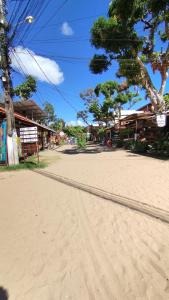 a dirt road with buildings on the side of a beach at Pousada Ponta da Baleia in Barra Grande