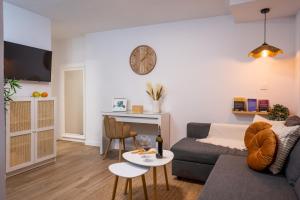 a living room with a couch and a clock on the wall at Refugio en Albaicín y parking in Granada