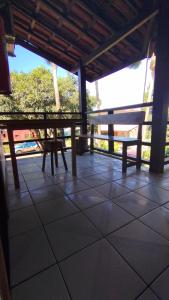 a porch with a table and benches on a tiled floor at Pousada Ponta da Baleia in Barra Grande