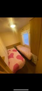 a small bedroom with a bed and a window at Static Caravan Marine Holiday Park in Rhyl