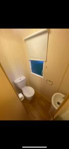 a small bathroom with a toilet and a window at Static Caravan Marine Holiday Park in Rhyl
