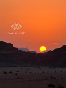 瓦迪拉姆的住宿－aالكـريـم AL KARIM LUXURY CAMP，沙漠中的橙色日落,有几何标志