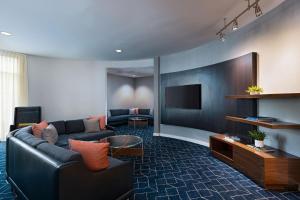 Courtyard by Marriott Boise West/Meridian في بويز: غرفة معيشة مع أريكة وتلفزيون بشاشة مسطحة