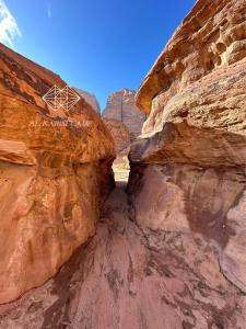 a slot canyon with a sign on the side of it at aالكـريـم AL KARIM LUXURY CAMP in Wadi Rum